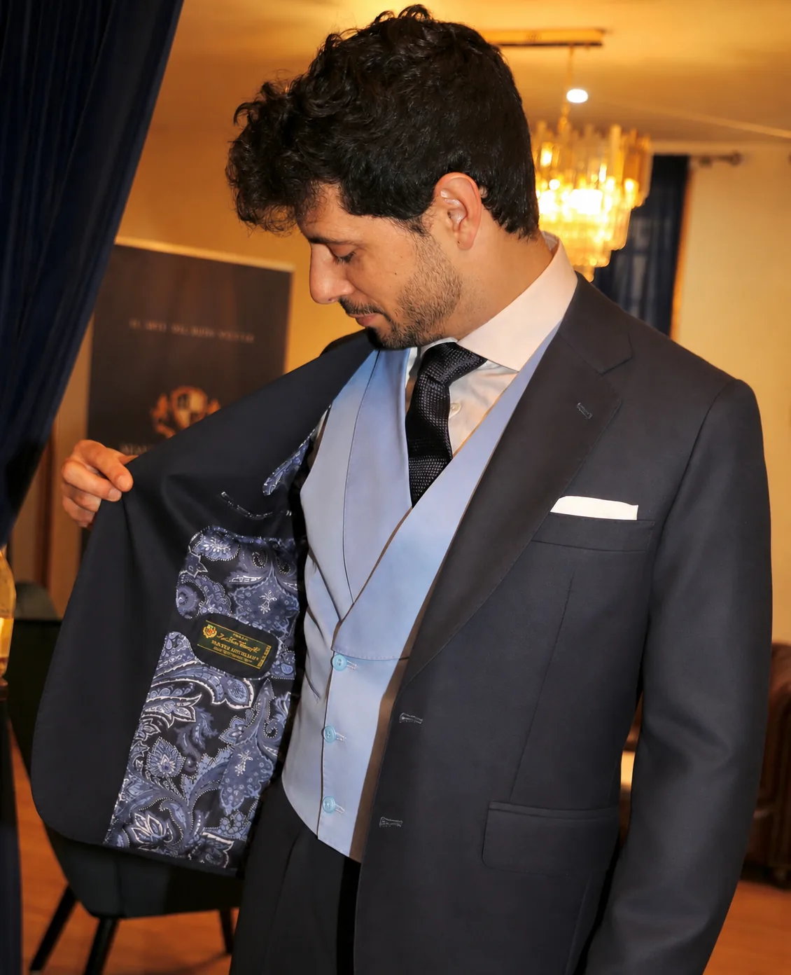 Traje azul marino abierto para mostrar el forro de paisley y el chaleco celeste